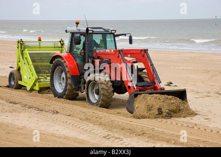 Tractor raking sand on beach in South Florida. Beach maintenance Stock