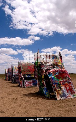 Tourist taking picture with camera at the Cadillac Ranch with buried cars in ground in Amarillo Texas USA Stock Photo