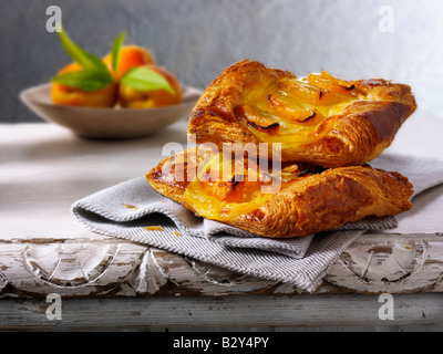 Glazed apricot pastry slice on a napkin on a rustic table Stock Photo