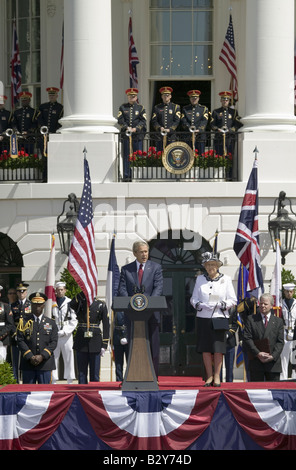 President George W. Bush speaking with Queen Elizabeth II standing to his left during the National Anthem Stock Photo