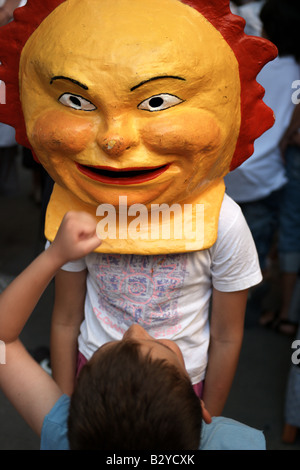 Children playing with masks at a traditional 'gathering of giants' in Barcelona, Catlonia, Spain Stock Photo