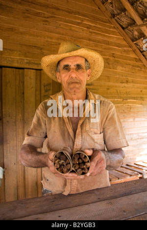 Portrait of Cuban tobacco farmer with bundle of hand rolled Cuban cigars home made and for sale Vinales Cuba Stock Photo