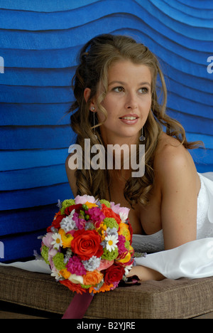Bride female 20s early 30´s elegant beauty beautiful wedding colourful flowers smile white wedding dress long curly hair Stock Photo