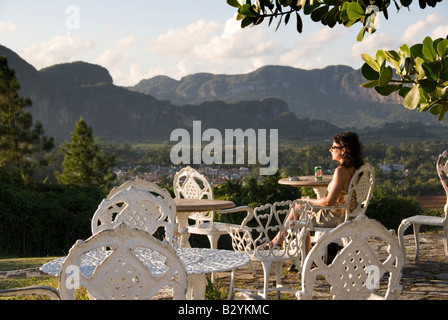 Model Released European tourist enjoying the view across a valley to steep mogote limestone hills of Viñales Cuba Stock Photo