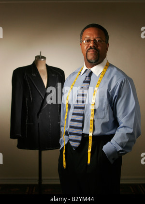 A professional tailor pictured with a tailor's dummy in his workshop. Stock Photo
