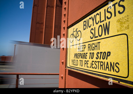 A traffic sign on the Golden Gate bridge warns bicyclists to slow down for pedestrians Stock Photo