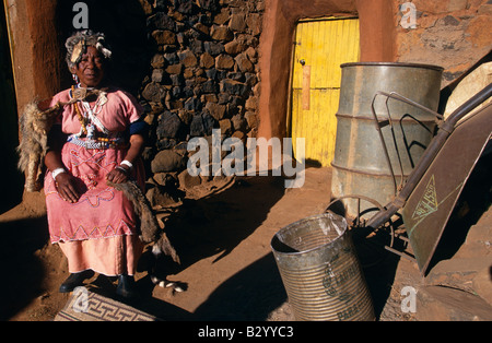 Sangoma, (traditional African healer) sitting outside house wearing traditional costume, portrait, Lesotho, Africa Stock Photo