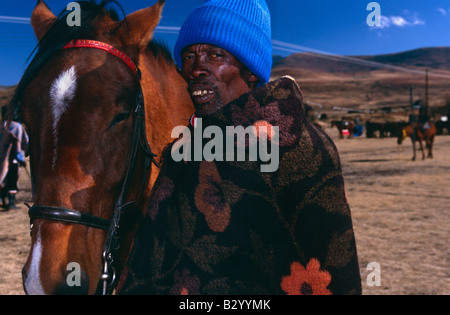 Man wrapped in basotho blanket with his horse, portrait, Lesotho, Africa Stock Photo