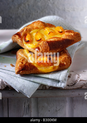 Glazed apricot pastry slice in a rustic setting on a wood table Stock Photo
