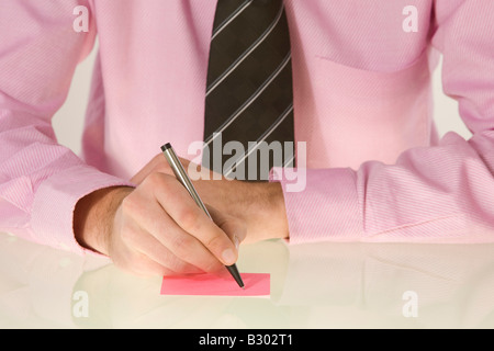 Businessman Writing on Sticky Note Stock Photo