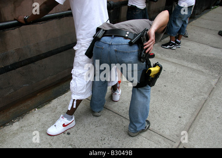 Plainclothes anti-crime police detectives searching suspects in Harlem New York City Stock Photo