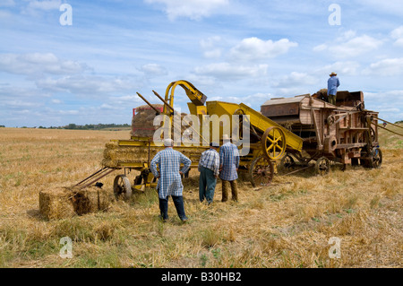 French farmers working thresher and baler machine at agricultural show, Indre, France. Stock Photo