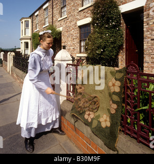 UK England County Durham Beamish Open Air Museum Alison Telfer maid beating a carpet Stock Photo