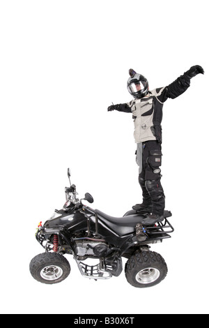 quod biker with helmet standing on his vehicle stretching out his arms Stock Photo