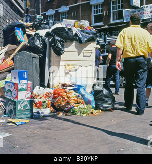 Rubbish spilling out of a bin on the pavement on a Sunday morning in Brick Lane London England UK  KATHY DEWITT Stock Photo