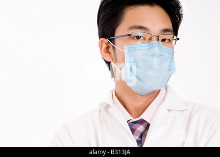 A young asian man in blue face mask and white coat Stock Photo