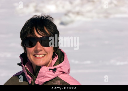 A lady is giving a big smill on the frozen Sea of Okhotsk near Sakhlalin island in the Russian Federation. Stock Photo