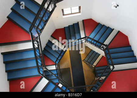 Downward view of a red, blue and white spiral staircase. Stock Photo