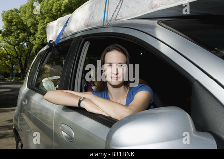 Young woman in Chevy Aveo leaving for college Stock Photo