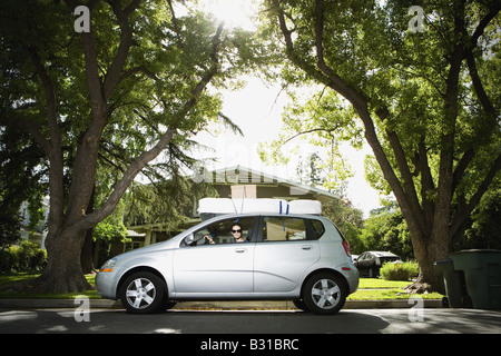 Young woman in Chevy Aveo leaving for college Stock Photo