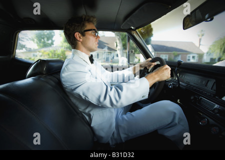 Young man driving in car to prom Stock Photo