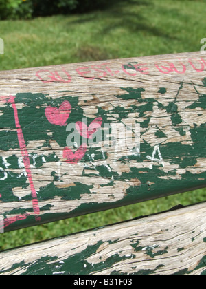 three love hearts painted on old green park bench Stock Photo