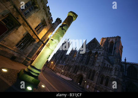 City of York, England. Night view of excavated Roman column and the southern façade of York Minster Cathedral at Minster Yard. Stock Photo