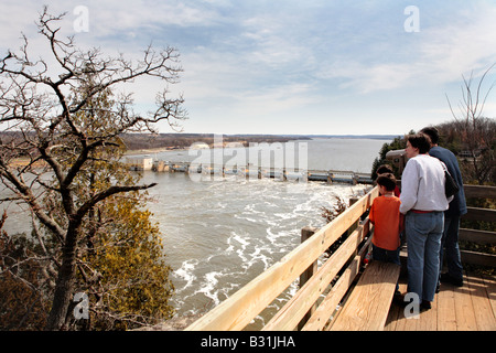 FAMILY LOOKING AT THE HYDROELECTRIC POWER PLANT ON ILLINOIS RIVER FROM A VIEWING PLATFORM IN STARVED ROCK STATE PARK NEAR UTICA Stock Photo
