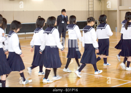 Japanese junior high school students walk across a gymnasium floor Stock Photo