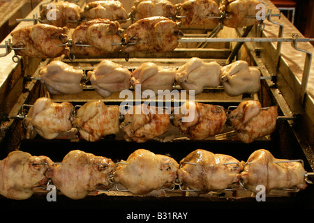 Skewered chickens being charcoal roasted on spits Stock Photo