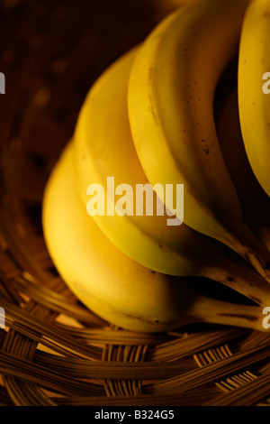 Hand of bananas in wicker basket Stock Photo
