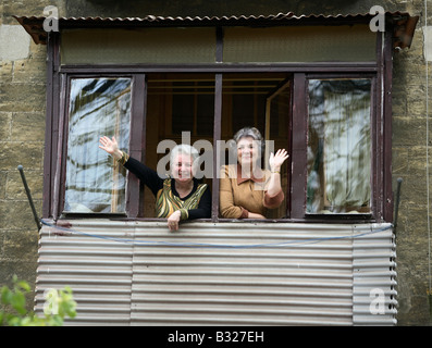 Two women standing in a window and waving, Odessa, Ukraine Stock Photo
