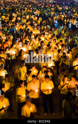 Crowds of Thai people in yellow take part in a candle light vigil to mark the Thai Kings 60th Anniversay to the throne Stock Photo