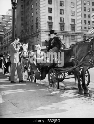 Riding in Style - carriage driver at Grand Army Plaza (edge of Central Park) getting ready to take customers through the Park Stock Photo