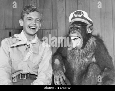 Laughing boy scout and monkey wearing hat Stock Photo