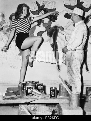 Dancing woman posing for mural painter Stock Photo