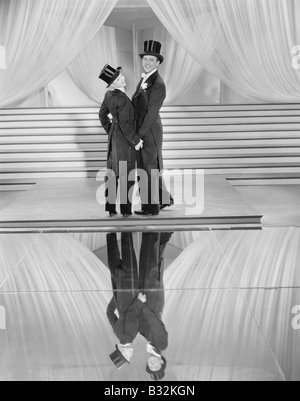 Couple posing in tuxedos and reflection Stock Photo