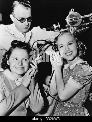 Women sharing pair of headphones Stock Photo