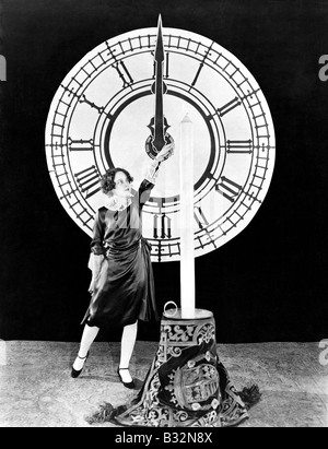 Woman with candle and clock on New Years Eve Stock Photo