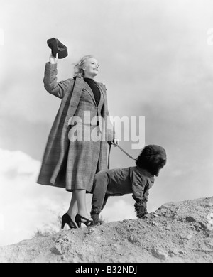 Woman walking dog on windy day Stock Photo