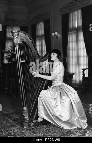 Woman playing harp Stock Photo