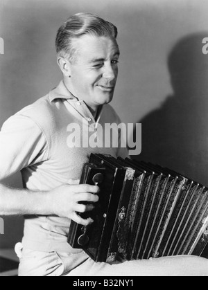 Winking man playing accordion Stock Photo