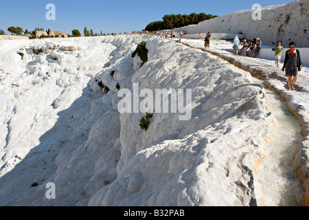 People walking on calcite terraces towards sulfur water pools at Pamukalle Turkey Stock Photo