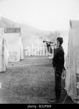 Soldier blowing bugle in army camp Stock Photo