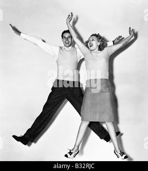 Couple jumping with their arms outstretched Stock Photo