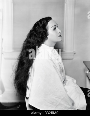 Profile of a young woman sitting in a hair salon with very long hair Stock Photo