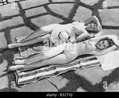 High angle view of two young women lying on a towel in the sun Stock Photo
