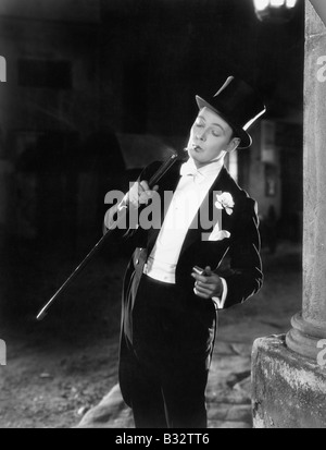 Young man in formal clothing lighting his cigarette with his walking stick Stock Photo