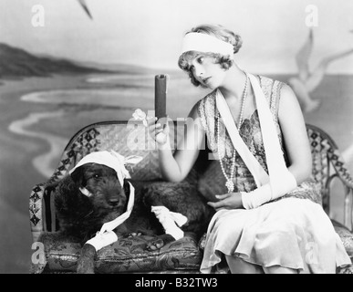 Injured woman and injured dog sitting on a couch Stock Photo