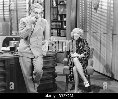 Woman in an office taking dictation and flirting with the man Stock Photo